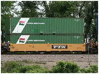A well car loaded with two forty-foot containers of Transportación marítima mexicana (TMM)