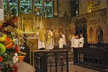 A priest stands at the right side of the altar to pray the Introit.