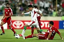 A Lebanese defender slide tackling an Iranian forward