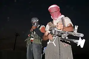 Two masked Iraqi men with weapons during the insurgency that followed the 2003 invasion of Iraq