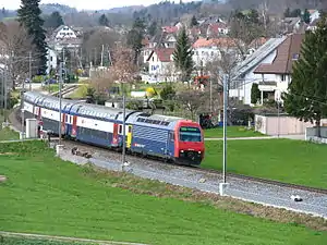 Red-and-blue locomotive pulling double-decker coaches