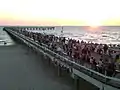 Pedestrians observing twilight on the pier