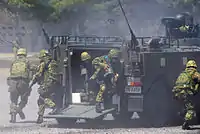 CRR soldiers rushing from a Type 96 APC