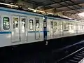 A JR East 301 series (left) and 103–1200 series (right) EMU formation at Funabashi Station, August 2002