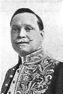 Man with moustache in ornate, high-collared shirt