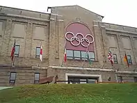 Photo of arena's two-storey brick exterior with the Olympic Rings above the entrance doors