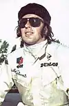 Jackie Stewart in a racing suit looking upwards