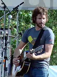 Singer James Blunt playing an acoustic guitar