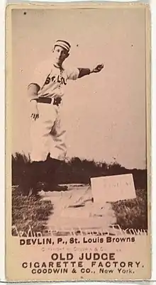 Standing man in baseball uniform in pitching stance