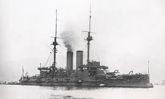 Large warship with smoke rising from the smokestack