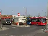 Two buses waiting in the bus station.