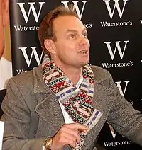 Donovan wearing a scarf and signing books in 2007