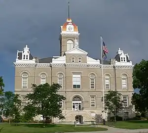 Two-story stone building with one-story clock tower above