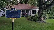 a picture of the marker with the house behind it