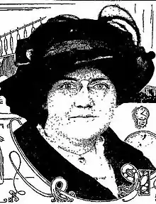 A white woman's face, under a large black hat.