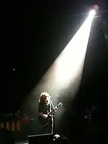 James under a spotlight onstage
