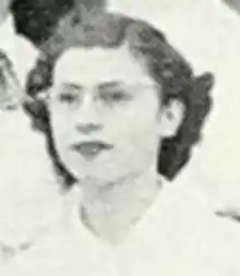 A young white woman with short wavy hair, wearing cat-eye glasses