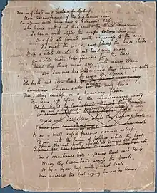 A white sheet of paper that is completely filled with a poem in cursive hand writing. Many of the lines mid-way down the page are scratched out.