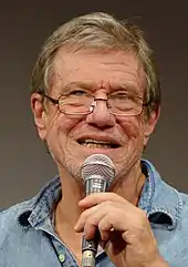 Director John McTiernan dressed in a blue shirt and glasses facing the camera