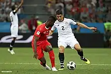 Photograph of two players trying to control a ball