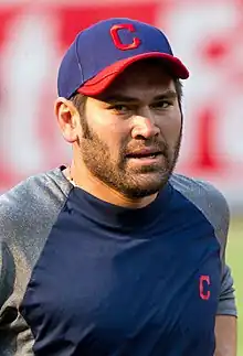 A man in a navy and gray shirt and navy and red cap