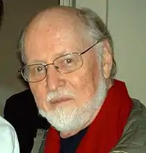 Composer John Williams, balding, with a beard and wearing glasses looking directly at the camera