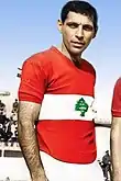 Joseph Abou Mrad wearing a red Lebanese jersey with a green cedar in the center inside a white horizontal band