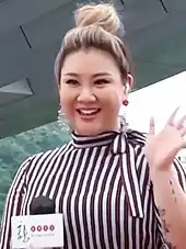 Close-up shot of Joyce Cheng waving with her left hand