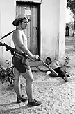 A Rhodesian Security Forces soldier swings a bat in front of a beaten prisoner in the fall of 1977. Taken for Associated Press. Third of three photos that were awarded a 1978 Pulitzer Prize.