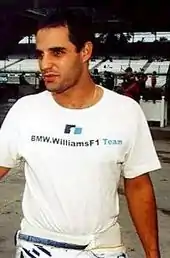 Photograph of Juan Pablo Montoya dressed in white looking to his left