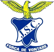 Juventude SC logo consisting of a white shield framed in blue with blue block letters 'JSC' running diagonally with a golden eagle perched atop it with wings outstretched