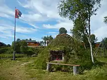 Goahti and flag in Mittådalen by the stream Mittån.