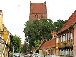Looking down Kirkestræde (Church Street) in Køge. Køge's church (Sankt Nicolai Kirke is behind the trees)