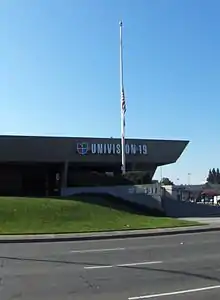 A one-story office building with "Univision 19" and "KUVS" signage