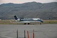 An aircraft located on a runway, with a mountain in the background