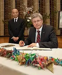 Prime Minister Stephen Harper signing a book of condolence for the victims of the 2011 Tōhoku earthquake and tsunami on March 23, 2011.