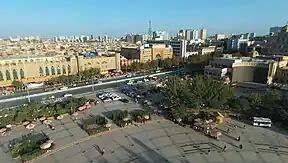 Birdseye view of Kashgar's city center. The older, brown buildings on the left contrast with the newer, colourful buildings on the right.