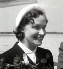 young white woman with dark hair, hatted and smiling widely