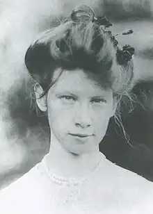 Black and white headshot of Yekaterina Stravinsky, wearing a white dress with her hair in a large bun