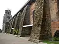 The thick buttresses of the church typical of earthquake baroque architecture.