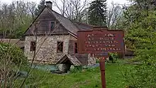 a picture of the rusted marker with the house in the background