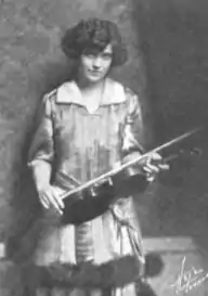 A young white woman holding a violin.