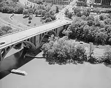 Aerial view of Key Bridge and George Washington Memorial Parkway, with pier of Aqueduct Bridge visible in the foreground and remnant of Aqueduct Bridge abutment visible on the Virginia shoreline (c. 1990)