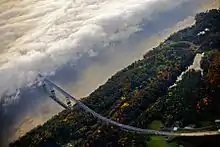 Aerial view of a bridge approaching a fog-covered river