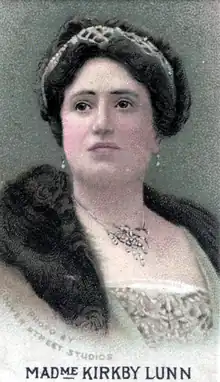 young to middle-aged white woman with dark hair, diamond necklace and fur collar