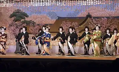 A group of geisha perform a dance onstage.