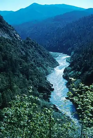 A view of a large river dividing forest-covered hills