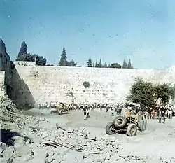 Israeli heavy-duty vehicles clearing up the demolished Moroccan Quarter ruins to create a plaza in front of the Western Wall, July 1967