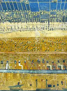 Walls of an ancient tomb, covered in paintings, showing gloden stars on a blue background, rows of hieroglyphs beneath.