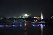 The bridge at night, along with Juche Tower to the right and fireworks for the Arirang Mass Games in background (2012)